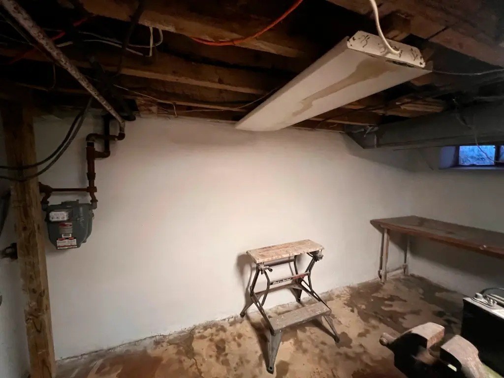 Before: broken, uneven basement floor ahead of replacement