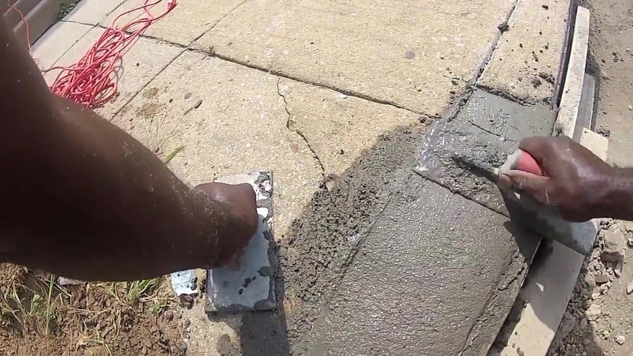 Crew hand-finishing a new concrete curb