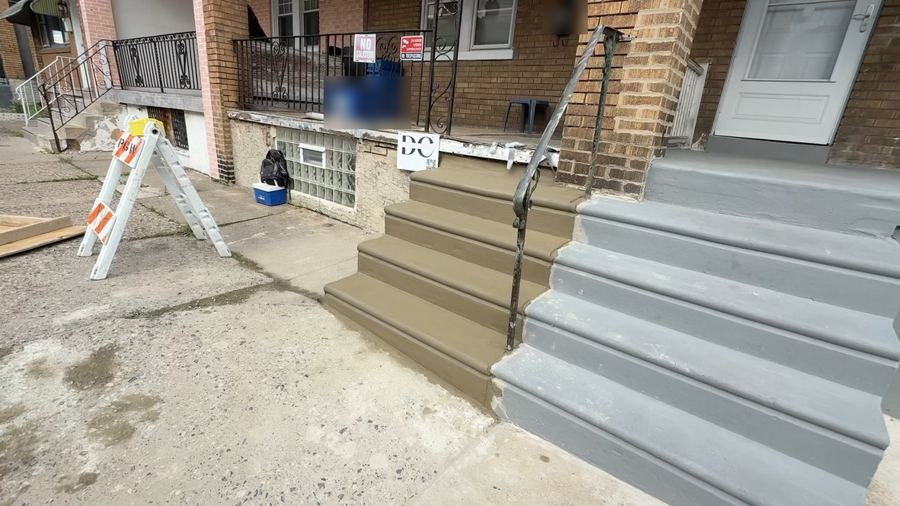 New concrete steps on one side of shared rowhome steps, cut along the party line, next to the neighbor's older grey steps in Philadelphia